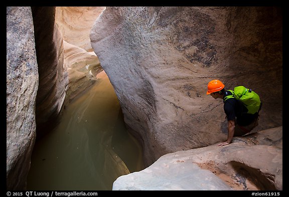 Canyoneer looks at water-filled pool. Zion National Park, Utah (color)