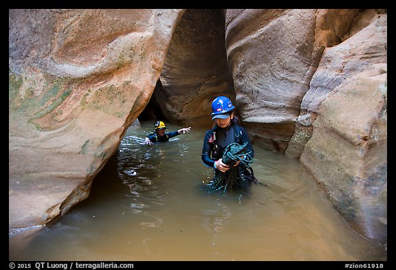 Woman carries rope, as man wades in chest-high water in Pine Creek Canyon. Zion National Park, Utah (color)