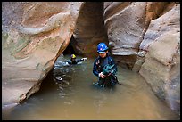 Woman carries rope, as man wades in chest-high water in Pine Creek Canyon. Zion National Park, Utah ( color)