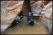 Woman carries rope, as man wades in chest-high water in Pine Creek Canyon. Zion National Park, Utah ( color)
