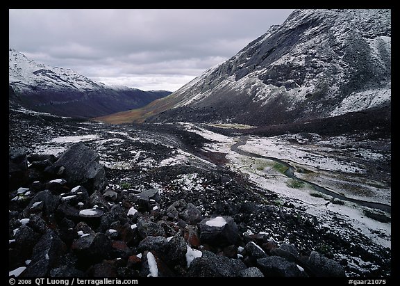 Boulders, valleys and slopes with fresh snow in cloudy weather. Gates of the Arctic National Park, Alaska, USA.