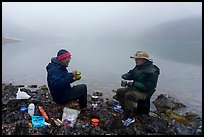 Backpackers eating on shore of foggy lake. Gates of the Arctic National Park ( color)