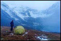 Camper standing by tent with fog approaching. Gates of the Arctic National Park ( color)