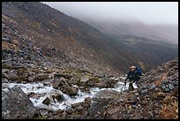 Hiker in rocky gorge, Three River Mountain. Gates of the Arctic National Park ( color)