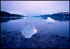 Beached translucent iceberg and Muir inlet at dawn. Glacier Bay National Park, Alaska, USA.