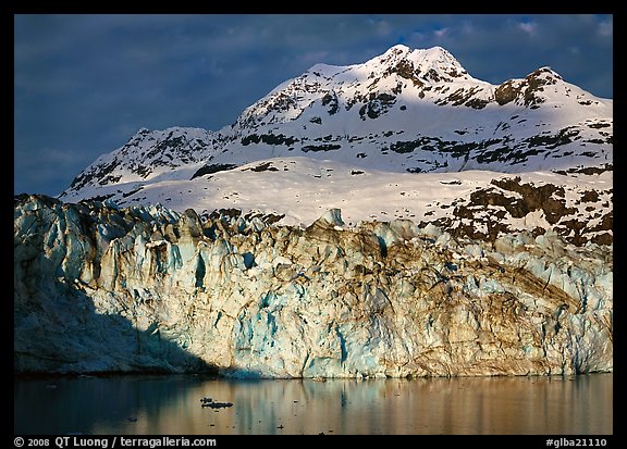 Face of Lamplugh Glacier illuminated by the sun on cloudy day. Glacier Bay National Park, Alaska, USA.