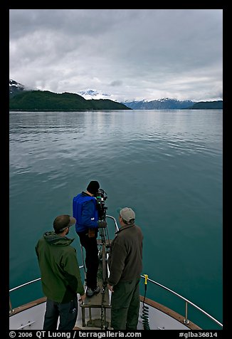 Film crew working on the bow of a small boat. Glacier Bay National Park (color)