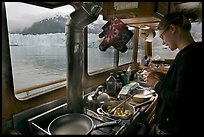 Woman preparing a breakfast aboard small tour boat. Glacier Bay National Park, Alaska, USA. (color)