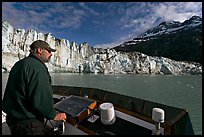 Captain guiding boat near Lamplugh glacier. Glacier Bay National Park, Alaska, USA.