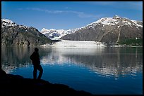 Man in silhouette looking at Tarr Inlet, Fairweather range and Margerie Glacier. Glacier Bay National Park, Alaska, USA.