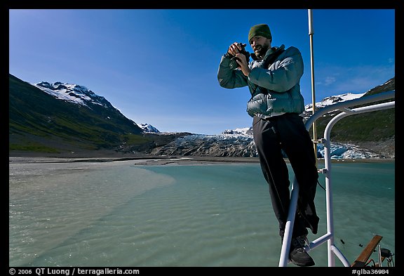 Photographer perched on boat with Reid Glacier behind. Glacier Bay National Park (color)