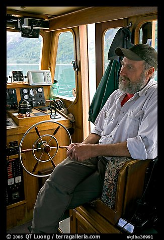 Captain sitting at the wheel. Glacier Bay National Park, Alaska, USA.