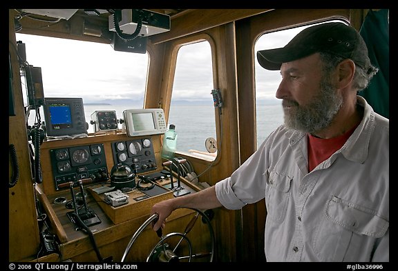 Captain steering boat with navigation instruments. Glacier Bay National Park (color)