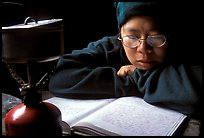 Backpacker reads log in abandonned geological survey cabin, Valley of Ten Thousand smokes. Katmai National Park, Alaska (color)