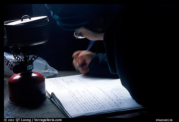 Backpacker writes into the log in USGS research cabins, Valley of Ten Thousand smokes. Katmai National Park, Alaska