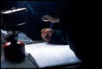 Backpacker writes into the log in USGS research cabins, Valley of Ten Thousand smokes. Katmai National Park, Alaska