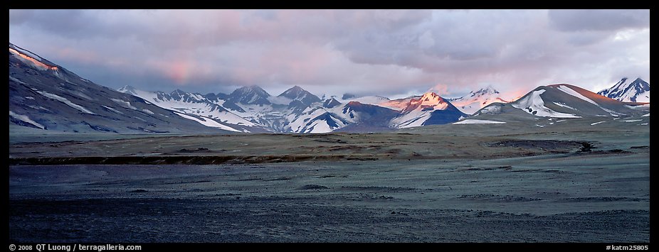 Desert-like ash-covered valley surrounded by snowy peaks. Katmai National Park, Alaska, USA.