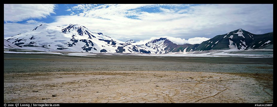 Snow-covered mountains surrounding ash-covered flats. Katmai National Park (color)