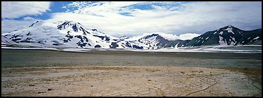 Snow-covered mountains surrounding ash-covered flats. Katmai National Park (Panoramic color)