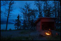 Camper sitting by campfire at night,  Brooks Camp. Katmai National Park, Alaska, USA.