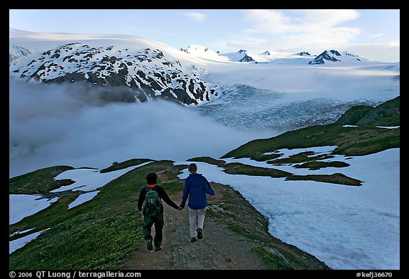 Couple hiking down Harding Icefied trail, late afternoon. Kenai Fjords National Park, Alaska, USA.