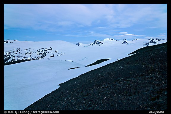 Rocky slope and snow-covered Harding Icefield at dusk. Kenai Fjords National Park, Alaska, USA.