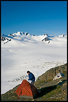 Camper exiting tent above the Harding ice field. Kenai Fjords National Park, Alaska, USA.