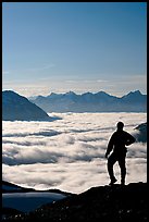 Man above a sea of clouds. Kenai Fjords National Park, Alaska, USA.