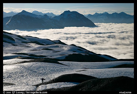 Mountains with snowboarder hiking down on snow-covered trail. Kenai Fjords National Park (color)