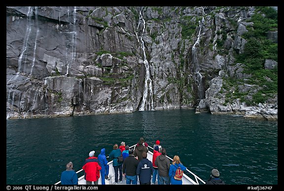 Waterfall viewing from deck of tour boat, Cataract Cove. Kenai Fjords National Park, Alaska, USA.