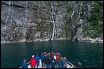 Waterfall viewing from deck of tour boat, Cataract Cove. Kenai Fjords National Park, Alaska, USA.