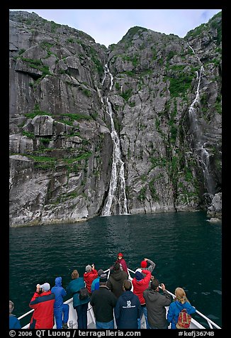 Passengers looking at waterfalls from  bow of tour boat, Cataract Cove. Kenai Fjords National Park (color)