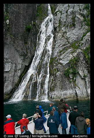 Passengers look at waterfall from tour boat, Cataract Cove, Northwestern Fjord. Kenai Fjords National Park, Alaska, USA.