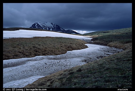 Snow nevesand mountains under dark storm clouds. Lake Clark National Park, Alaska, USA.