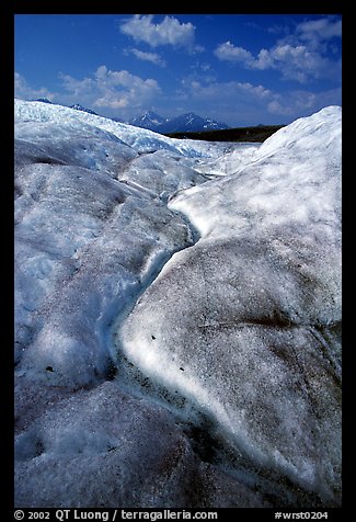 Ice, glacial creek on Root glacier, and mountains. Wrangell-St Elias National Park, Alaska, USA.