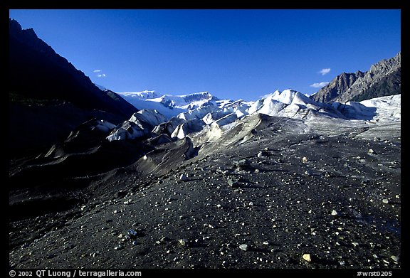 Morainic debris on Root glacier with Wrangell mountains in the background, late afternoon. Wrangell-St Elias National Park, Alaska, USA.