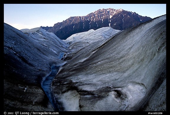 Root Glacier, glacial stream, and mountains at dusk. Wrangell-St Elias National Park, Alaska, USA.