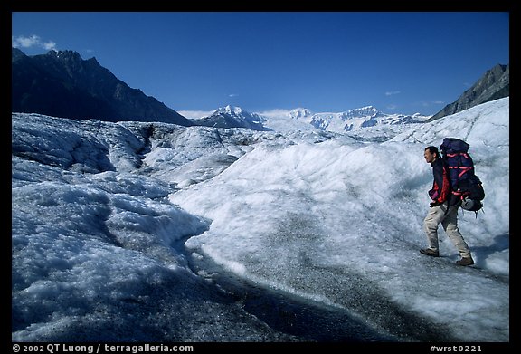 Backpacker with large pack on Root glacier. Wrangell-St Elias National Park (color)