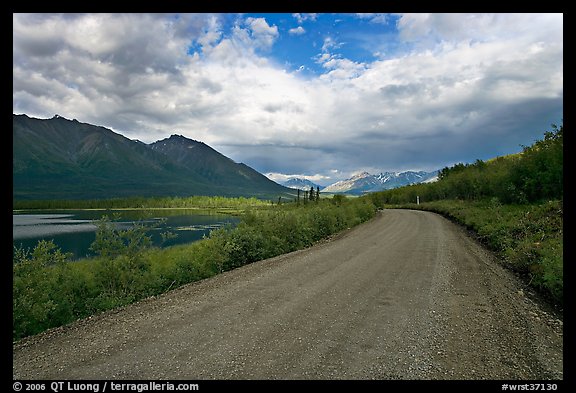 Unpaved McCarthy Road next to lake. Wrangell-St Elias National Park, Alaska, USA.