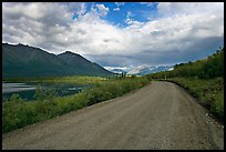 Unpaved McCarthy Road next to lake. Wrangell-St Elias National Park, Alaska, USA.
