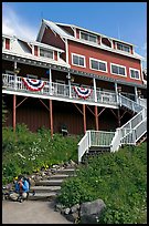 Hiker sitting on steps of Kennicott Lodge. Wrangell-St Elias National Park ( color)