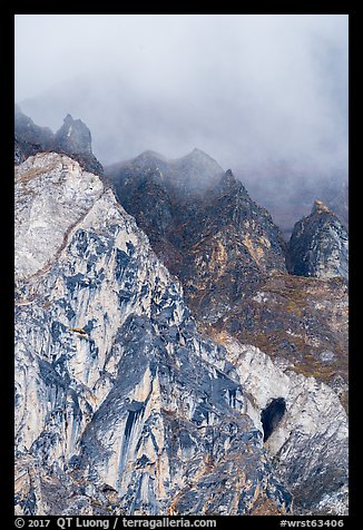 Distant rock arch below cloud-shrouded mountain. Wrangell-St Elias National Park (color)