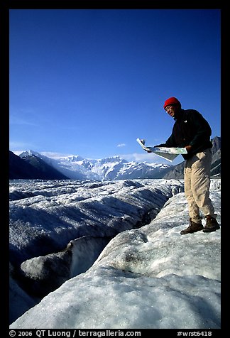 Hiker checks map on Root Glacier. Wrangell-St Elias National Park, Alaska, USA.