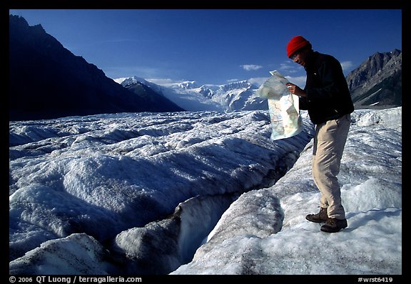 Hiker checks map on Root Glacier. Wrangell-St Elias National Park, Alaska, USA.