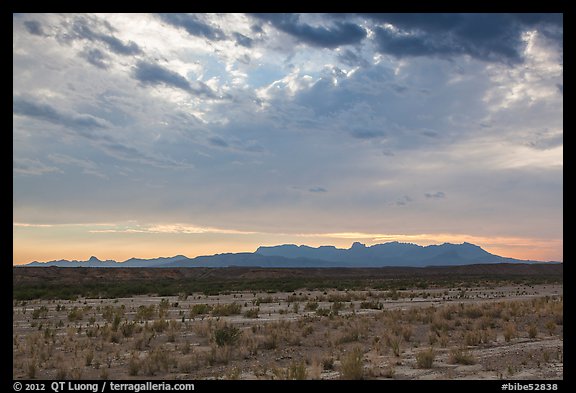 Dry riverbed, distant Chisos Mountains, and clouds. Big Bend National Park, Texas, USA.