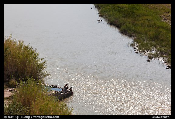 Couple sitting on edge of hot springs seen from above. Big Bend National Park, Texas, USA.