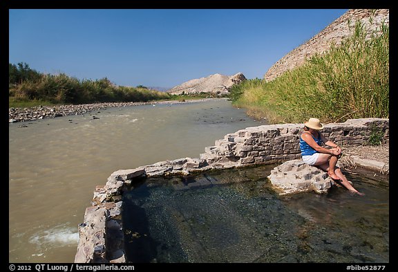 Tourist sitting in hot springs next to river. Big Bend National Park, Texas, USA.