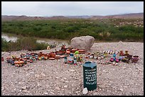 An unmanned spread of Mexican pottery is watched over only by a green honor-system can, the border landscape stretching into hazy ridges beyond.. Big Bend National Park ( color)