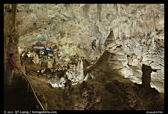 Park visitor looking, large illuminated room filled with speleotherms. Carlsbad Caverns National Park, New Mexico, USA.