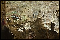 Park visitor looking, large illuminated room filled with speleotherms. Carlsbad Caverns National Park, New Mexico, USA.